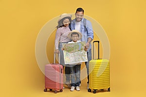 Happy Black Family With Little Son Looking At Map, Planning Travel