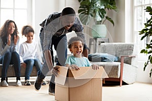 Happy black family play with kids moving to new home