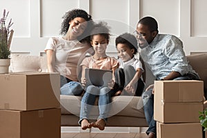 Happy black family sitting in living room with computer.