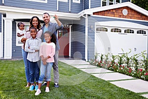 Happy black family standing outside their house, dad holding the key