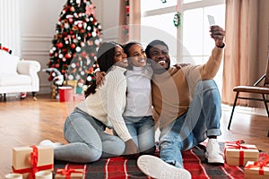 Happy black family taking selfie on Xmas