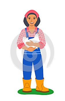 Happy black farmer woman stands and holds white chicken in her hands