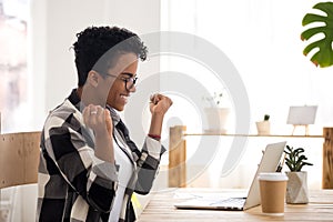 Excited woman feels happy sitting at the desk indoors photo