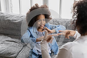 Happy Black girl talking to disabled deaf mom