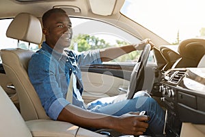 Happy black guy driving car, going to job