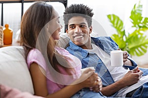 Happy black guy looking at his girlfriend with admiring glance