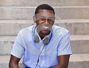 Happy black guy sitting with headphones