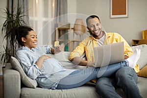 Happy Black Husband And Pregnant Wife Shopping Online At Home