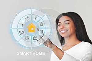 Happy black lady touching virtual Smart home screen