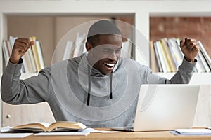 Happy black male student get pleasant email on laptop