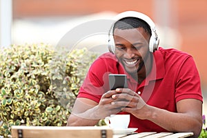 Happy black man listening to music in a bar