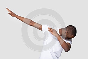 Happy black man making dab gesture on blank studio background