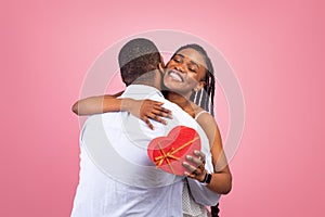 Happy black man making surprise for woman giving box