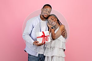 Happy black man making surprise for woman giving box