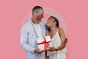 Happy black man making surprise for woman giving box