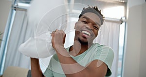 Happy black man, pillow fight and playing in bed, POV or fun bonding relationship together at home. Portrait of African