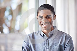 Happy black man, portrait and window with ambition for career, job or creative startup at office. Face of African male