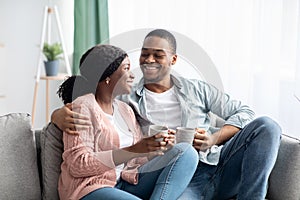 Happy black man and woman enjoying weekend at home together