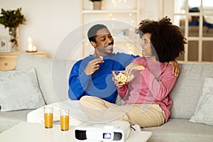 Happy Black Millennial Couple Enjoying Movie Night Together At Home