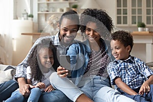 Happy parents and cute sibling kids watching online media content