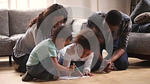 Happy black mom dad and kids drawing together at home