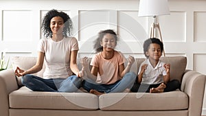 Happy black mother with son and daughter meditating.
