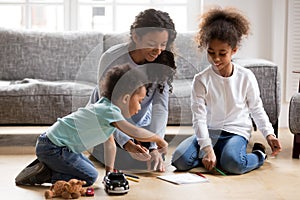 Happy black single mom and 2 kids draw with pencils