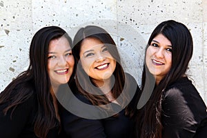 Happy black straight hair latin adult sisters dressed in black for family photo shoot in harmony and joy