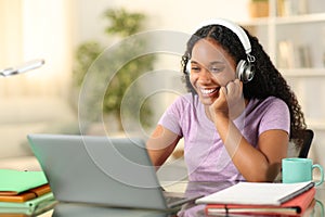 Happy black student eleaning online at home photo