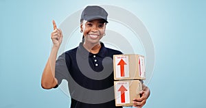 Happy black woman, box and pointing up for delivery, logistics or order against a blue studio background. Portrait of