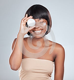 Happy, black woman and container with cream for skincare or moisturizer on a white studio background. Face of African