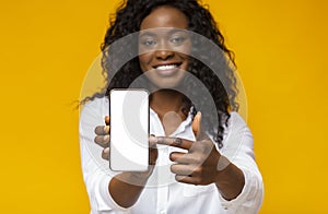 Happy black woman holding latest slim smartphone