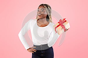 Happy black woman holding present box and smiling
