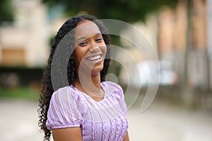 Happy black woman laughing standing in the street