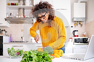 Happy black woman learning to cook at home with online courses