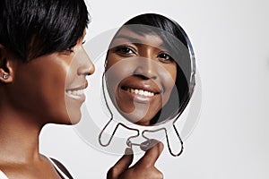 Happy black woman with mirror