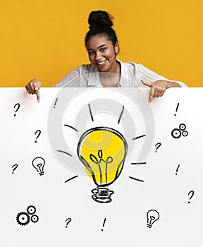 Happy black woman pointing at banner with drawing of light bulb, gears and question marks