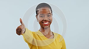 Happy black woman, portrait and thumbs up in winning, success or good job against a gray studio background. African