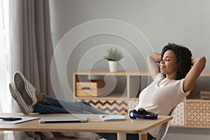 Happy black woman relax in chair at desk at home