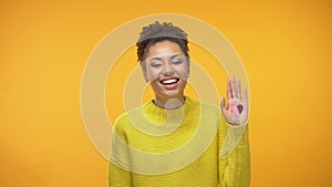 Happy black woman showing open palm with heart sign, sincere love, relationships