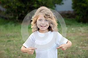 Happy blond child indicating himself an loughing photo