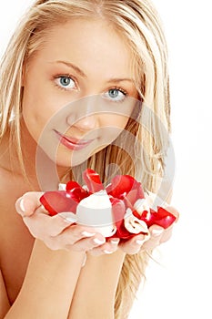 Happy blond in spa with red and white rose petals