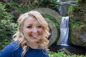 Happy blond woman 30-35 years old poses at Multnomah Falls in Oregon