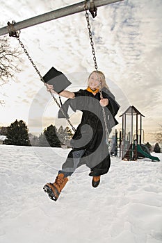 Excited college graduate on swingset photo
