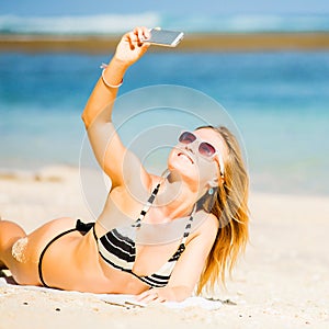 happy blond young female in sunglasses taking