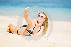 happy blond young female in sunglasses taking