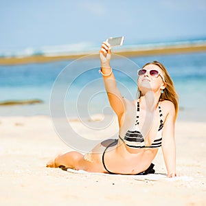 happy blond young female in sunglasses taking