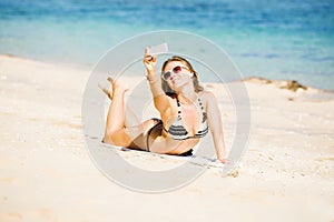 happy blond young female in sunglasses taking