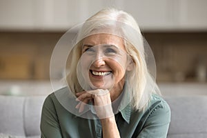 Happy blonde elderly woman having fun at home