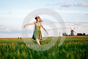 Happy blonde girl, dancing in a field full of yellow flowers. background of summertime and blue skies.